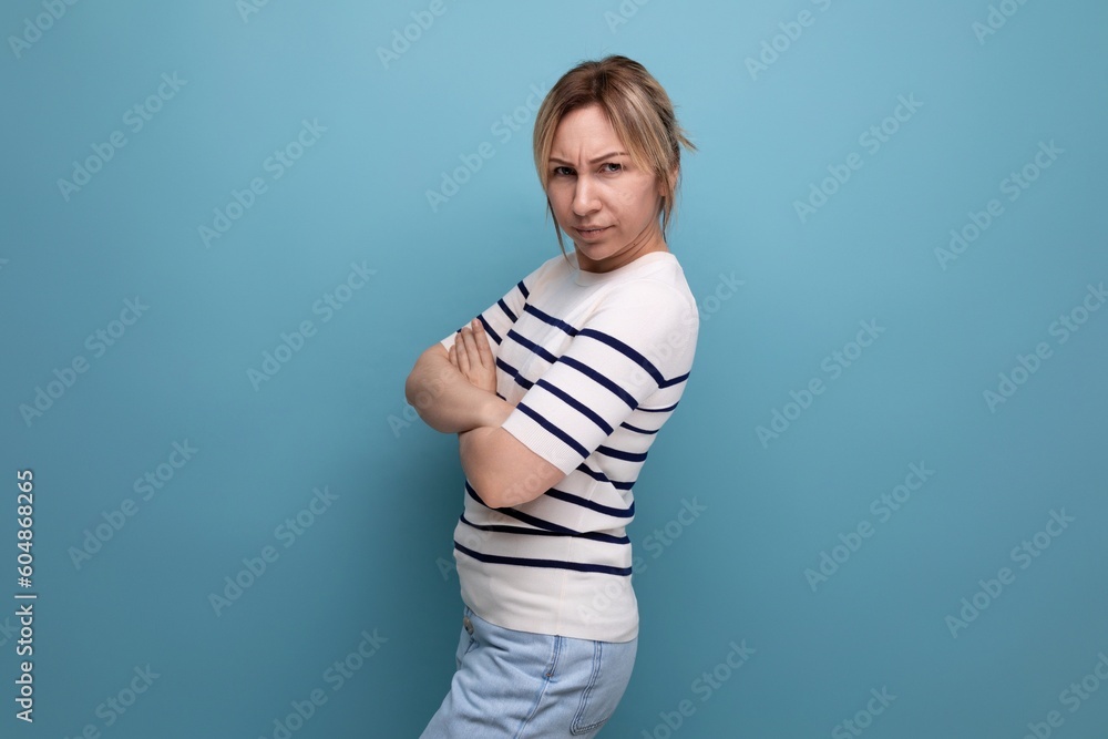 serious sullen blond girl on a blue background with copyspace serious sullen blond girl on a blue background with copyspace