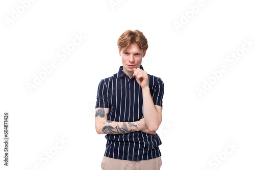 smart hipster young blond guy in a striped polo shirt with a tattoo thinks on a white background