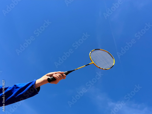 Hand holds racquet for badminton preparing to take a shot
