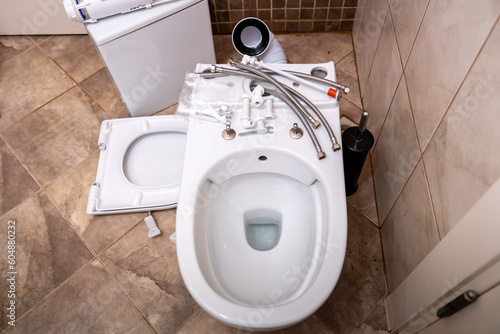 Installing a new toilet bowl in the restroom and its accessories, plumbing repair service, cleaning, assembly, repair and installation concept