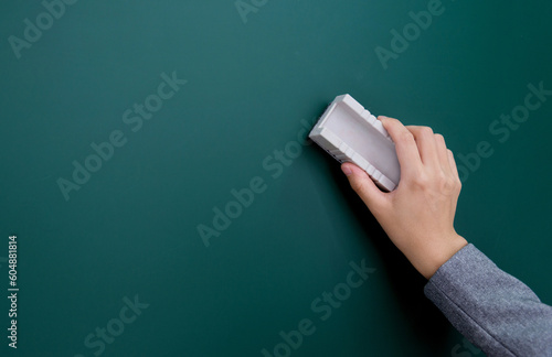 Quadro em tela Hand holding brush erase on blackboard
