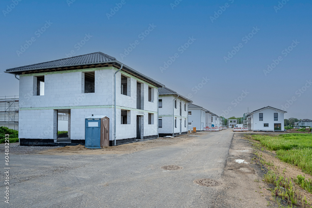Baustraße im Neubaugebiet mit Häusern Baustraße im Neubaugebiet mit Häusern