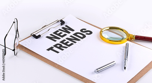 NEW TRENDS text on clipboard on white background, business concept