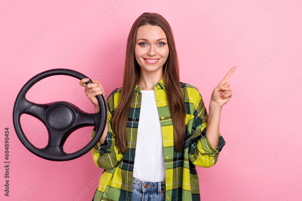 Photo of young beautiful woman wear checkered jacket steering wheel direct finger mockup car safety insurance isolated on pink color background - obrazy, fototapety, plakaty 