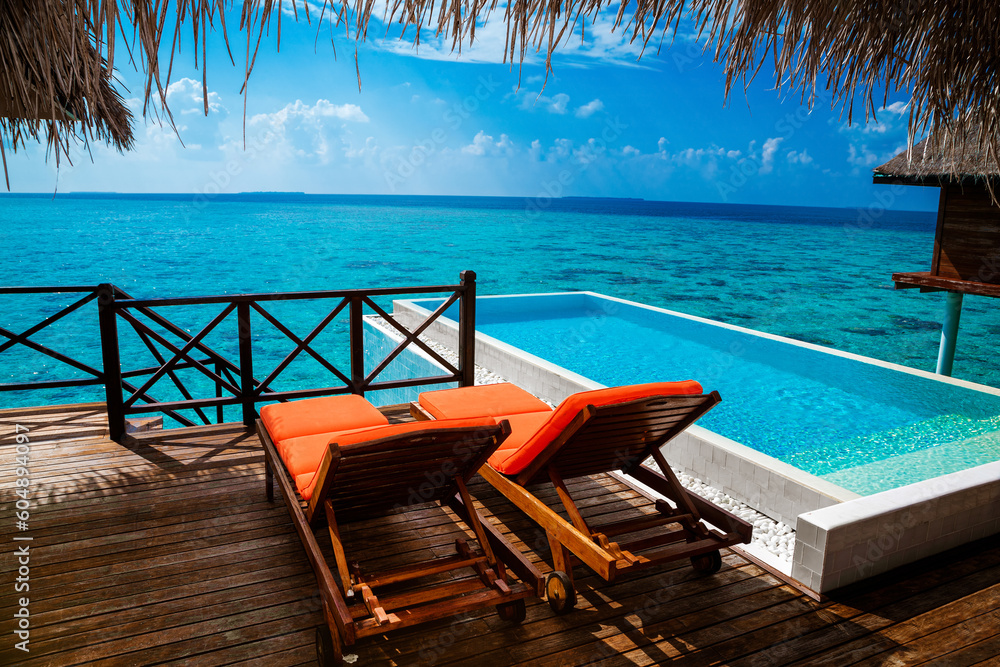Landscape on Maldives island, luxury water villas resort with pool. Beautiful sky and ocean and pool with turquoise water for summer vacation holiday and travel concept. Luxury travel. Tourism. Landscape on Maldives island, luxury water villas resort with pool. Beautiful sky and ocean and pool with turquoise water for summer vacation holiday and travel concept. Luxury travel. Tourism.