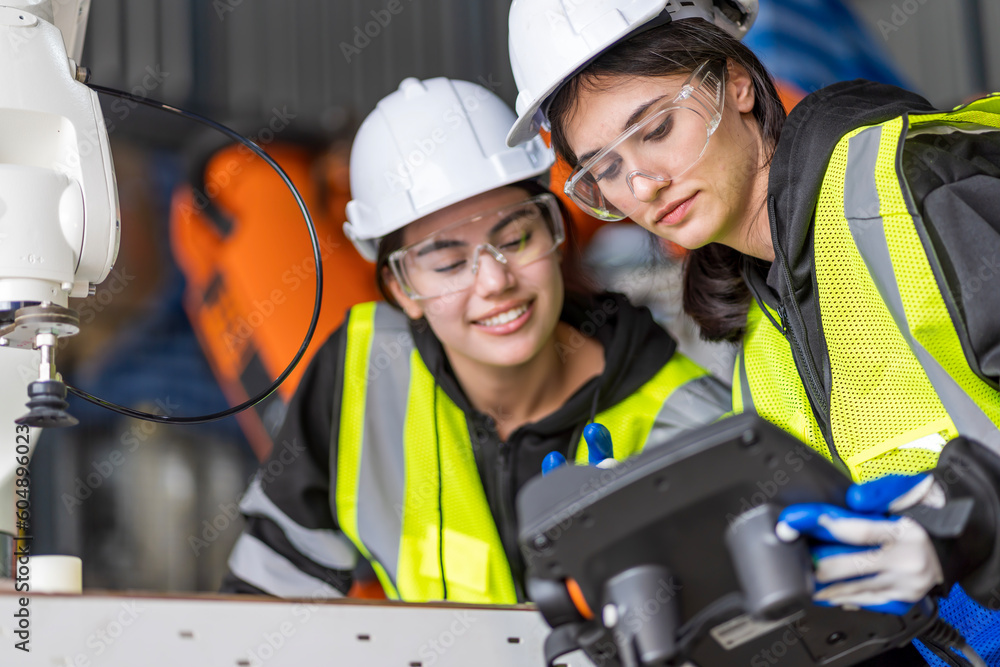 A team of female engineers meeting to inspect computer-controlled steel welding robots. Plan for rehearsals and installation for use. A team of female engineers meeting to inspect computer-controlled steel welding robots. Plan for rehearsals and installation for use.