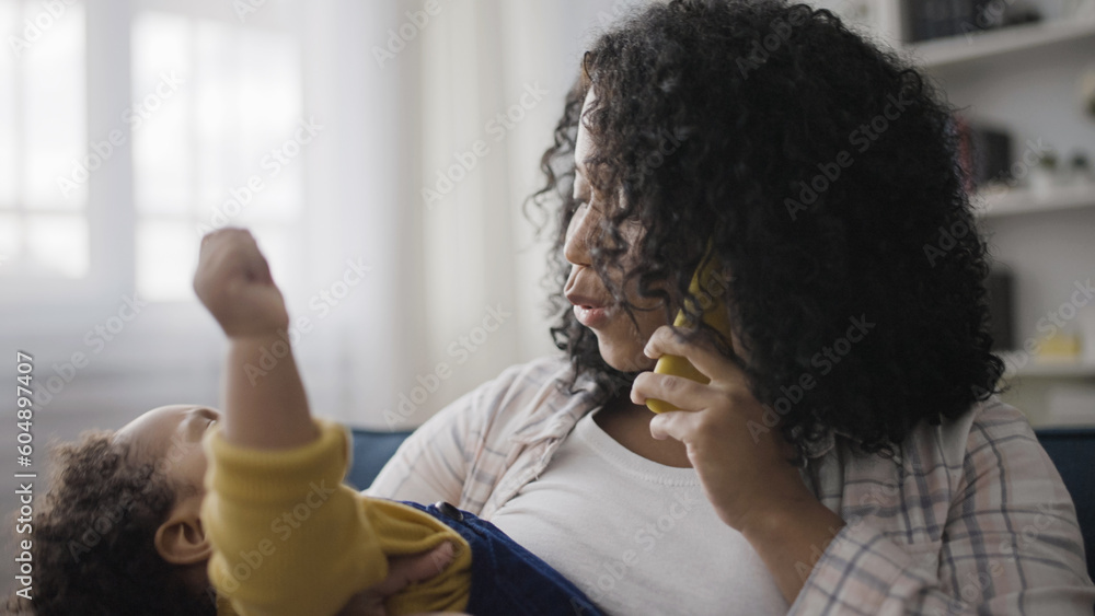 Baby boy cries in mom's hands while she talks on the phone, maternity leave, parenting Baby boy cries in mom's hands while she talks on the phone, maternity leave, parenting