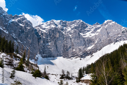 View of the rock wall in Enger Grund amidst snowy alpine landscape with small snow avalanches