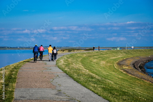 Fußganger auf dem Deich des Rantumer Beckens auf Sylt