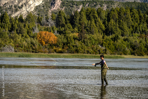 Young man practices sport fly fishing in the Rio Grande or Futaleufú, in Chubut, Patagonia Argentina. photo