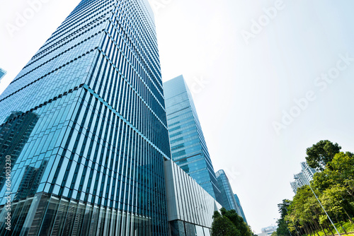 Modern glass buildings and green tree branches