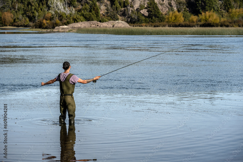 Young man practices sport fly fishing in the Rio Grande or Futaleufú, in Chubut, Patagonia Argentina. Young man practices sport fly fishing in the Rio Grande or Futaleufú, in Chubut, Patagonia Argentina.