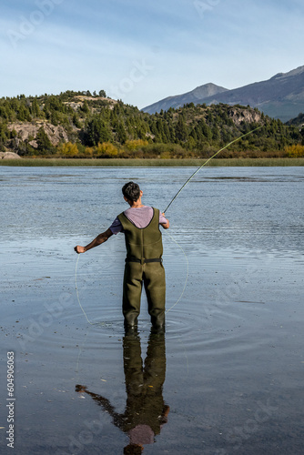 Young man practices sport fly fishing in the Rio Grande or Futaleufú, in Chubut, Patagonia Argentina. photo