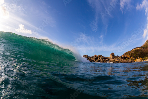 huge wave breaking on a beach with no people