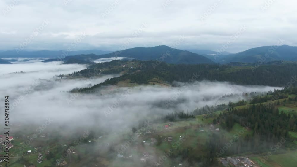 Wide shot mist over Carpathian mountains on overcast morning. Aerial view of foggy landscape in Ukraine Wide shot mist over Carpathian mountains on overcast morning. Aerial view of foggy landscape in Ukraine