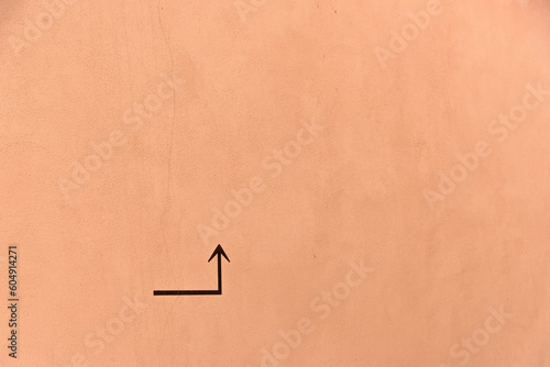 Arrow up and around the corner on an ocher colored background