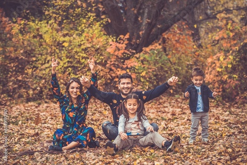 Happy smiling beautiful family playing and laugh in the forest