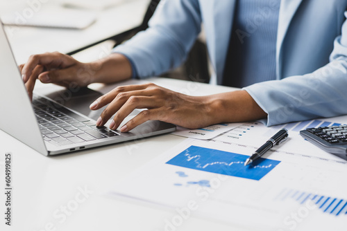 Businesswoman working with laptop and financial documents on desk, financial and investment data analysis, financial planning and accounting.