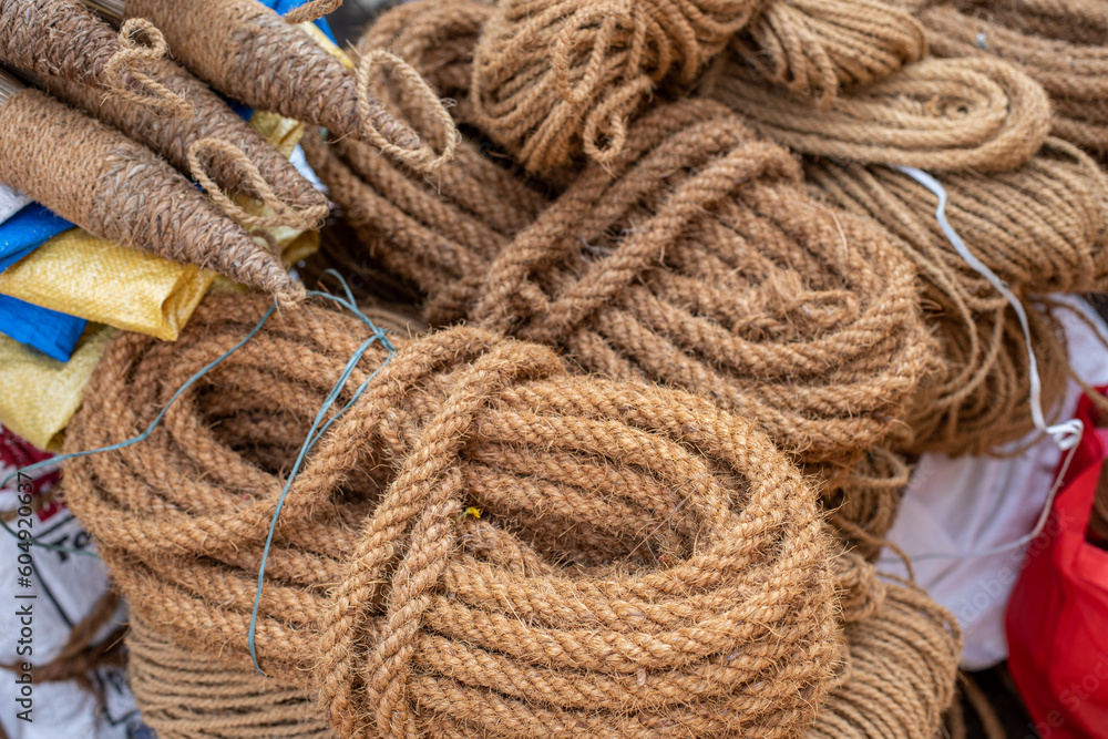 Natural jute rope of various thicknesses is wound in circles, coils, put up for sale at street market. Natural fibers.