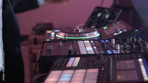 A DJ works on his sound mixing board at an event - closeup photo