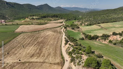 Varios motoristas por pista de tierra en las montañas un dia soleado