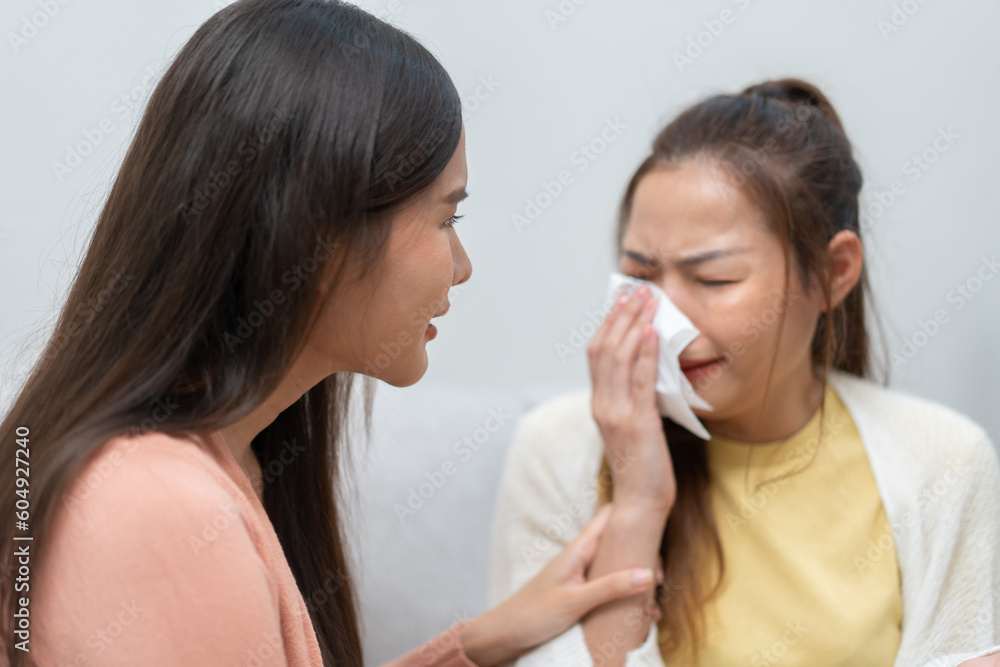 Two women talking about problems at home. Asian women embrace to calm their sad best friends from feeling down. Female friends supporting each other. Problems, friendship, and care concept