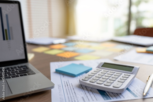 Office desk with data documents calculator and laptop..