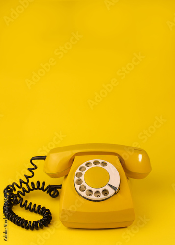 yellow bright retro telephone on a bright yellow background. for banners, advertisements, flyers, screensavers, covers, invitation cards, etc.