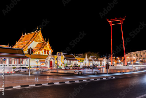 Wat Suthat Thep Wararam and the saochingcha at night with the lights from the cars that are out of focus, which are popular photos of Bangkok's famous night tourists.