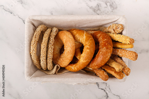 Freshly baked delicious bread, bagel, pretzel and breadsticks on a old rustic basket. Copy space. Top view. Healthy eating concept. Flat lay