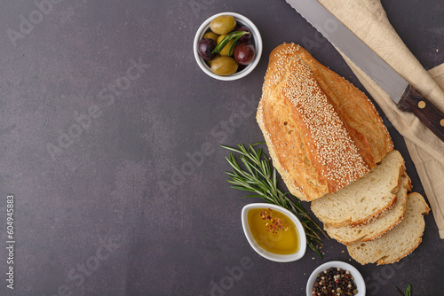 Sliced loaf of bread on a dark rustic table background. Top view. Copy space