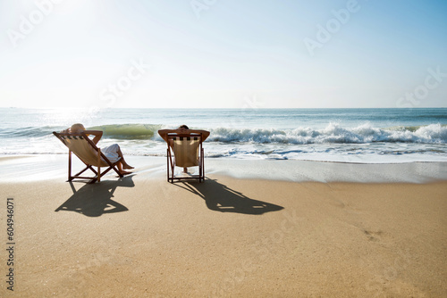 Couple sunbathing on a beach chair.