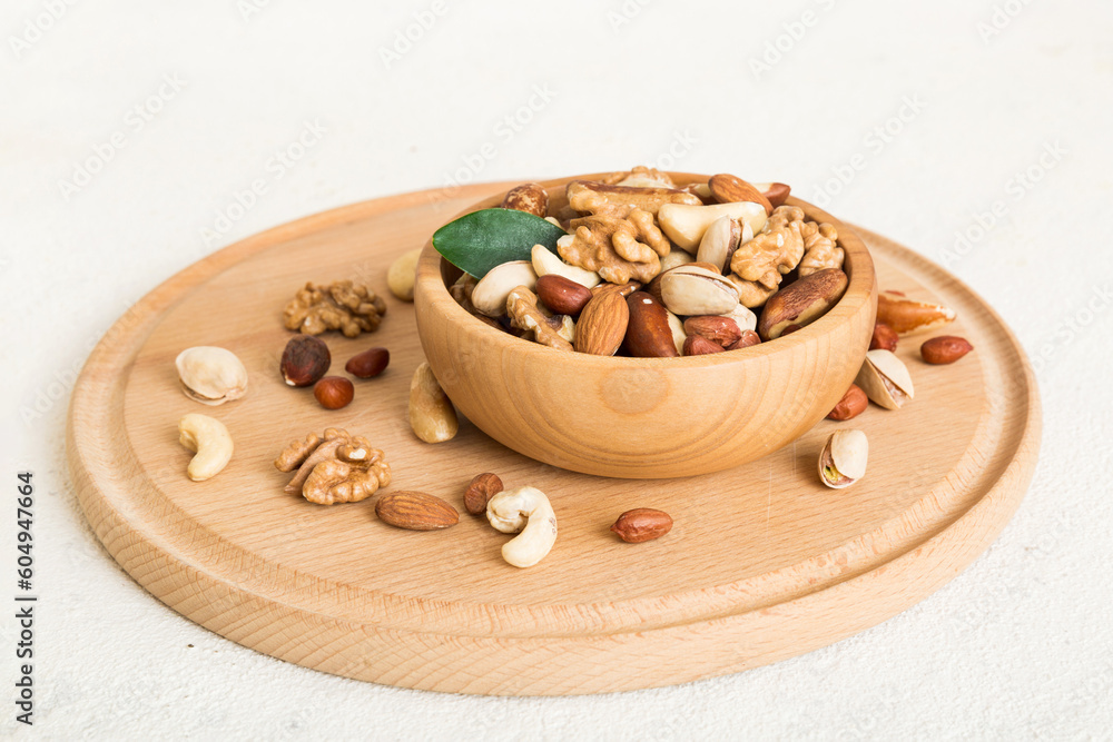 Fototapeta premium mixed nuts in bowl. Mix of various nuts on colored background. pistachios, cashews, walnuts, hazelnuts, peanuts and brazil nuts