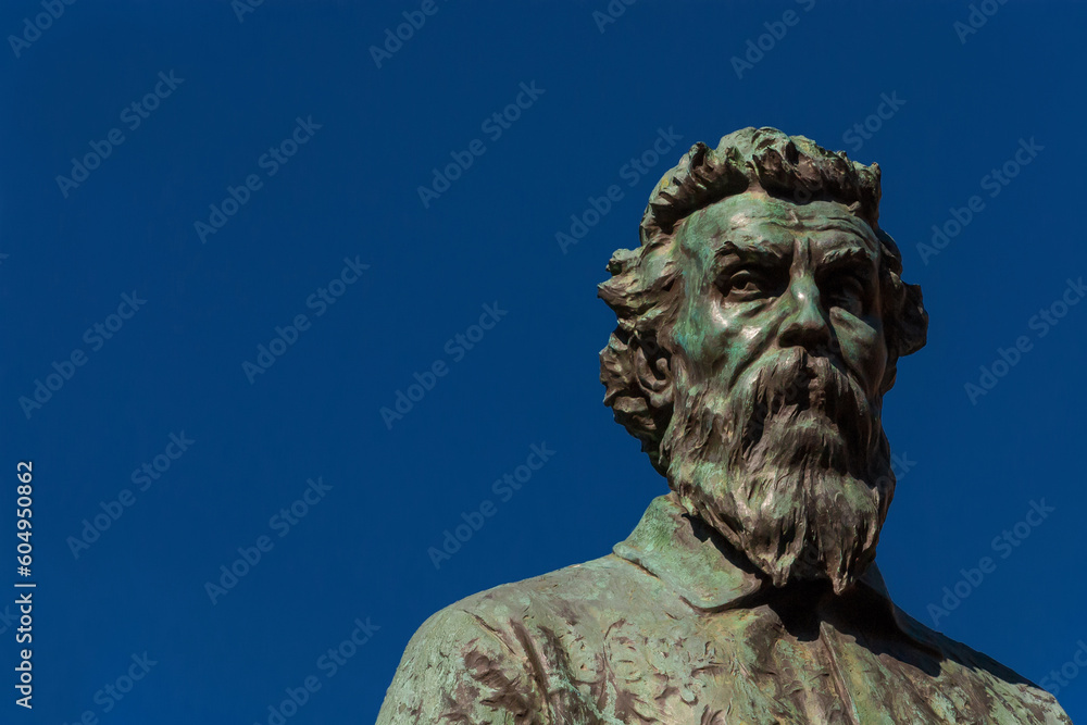 Benvenuto Cellini, a famous Italian Renaissance goldsmith and sculptor. Old bronze monument erected in 1901 on Ponte Vecchio (Old Bridge) in Florence (with blue sky and copy space)
