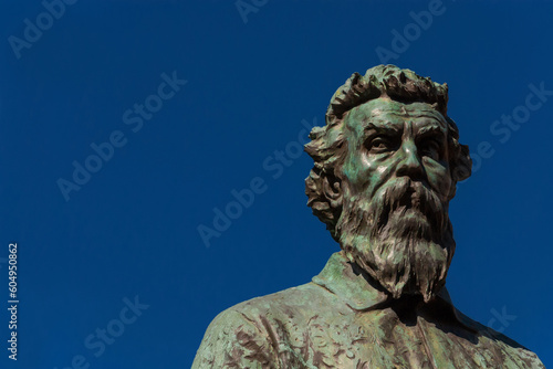 Benvenuto Cellini, a famous Italian Renaissance goldsmith and sculptor. Old bronze monument erected in 1901 on Ponte Vecchio (Old Bridge) in Florence (with blue sky and copy space) © crisfotolux
