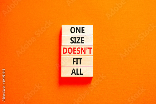 One size does not fit all symbol. Concept words One size does not fit all on wooden blocks. Beautiful orange table orange background. One size does not fit all business concept. Copy space.