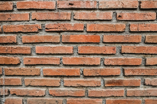 Texture of a red bricks wall. Old castle stone wall. Pattern red color of modern style design decorative uneven real stone wall surface with cement. Brick texture for wallpaper or background.