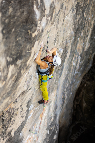 woman climbing big walls in the mountains, doing sports, striving hard for her goals without fear of success, courageous person, confident person with commitment.