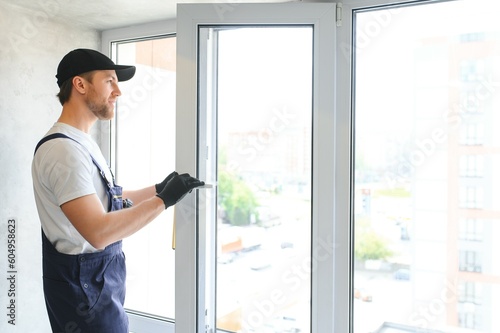 Construction worker installing window in house