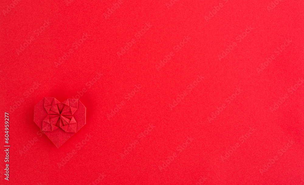 Obraz premium Red origami heart on red background