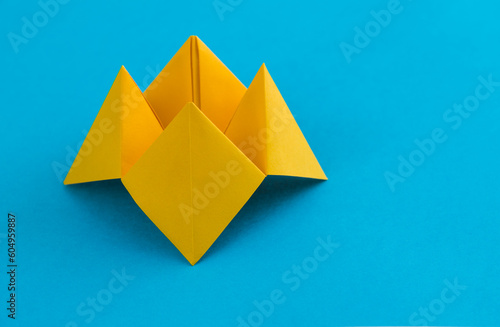 Origami paper fortune on blue background photo