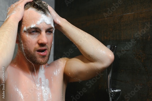 The man is washing his hair, he use shampoo.