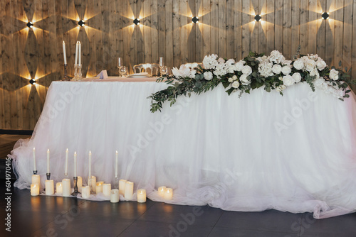 Obraz na płótnie The elegant and classic area of the Newlyweds table is decorated with flowers and candles. Beautiful decoration of the wedding table. w salonie