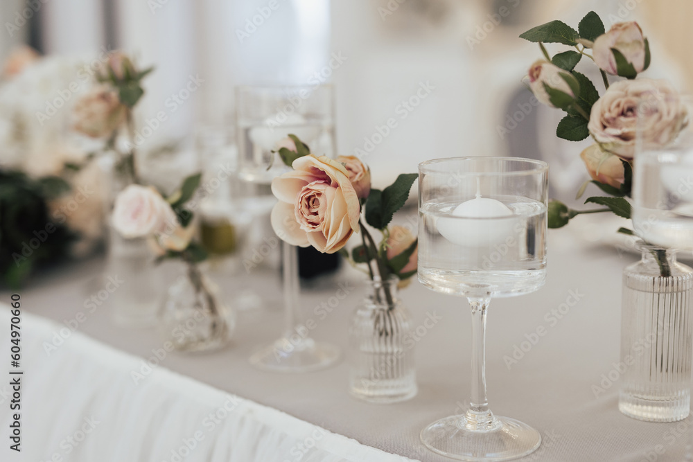 Vases decorated with flowers and candles on the table for holiday.