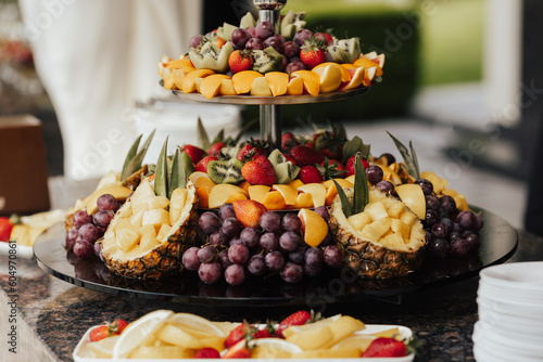 Obraz na płótnie Plate with different kind of fruits. Luxury gorgeous wedding buffet with oranges, grape, pineapple, strawberries and kiwi. w salonie