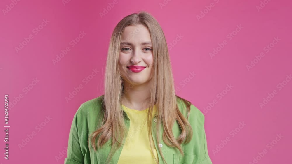 Young woman with money gesture on pink studio background.Smart lady smiles slyly Young woman with money gesture on pink studio background.Smart lady smiles slyly