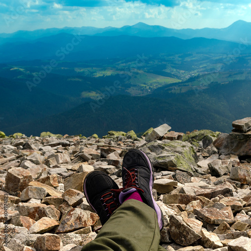 Hiking in the mountains. A tourist's feet on top of a mountain