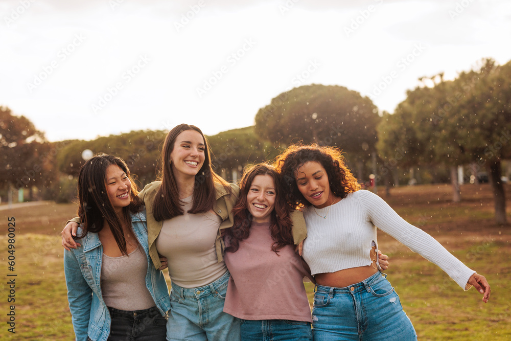 Four interracial young friends walking and smiling together. Four interracial young friends walking and smiling together.