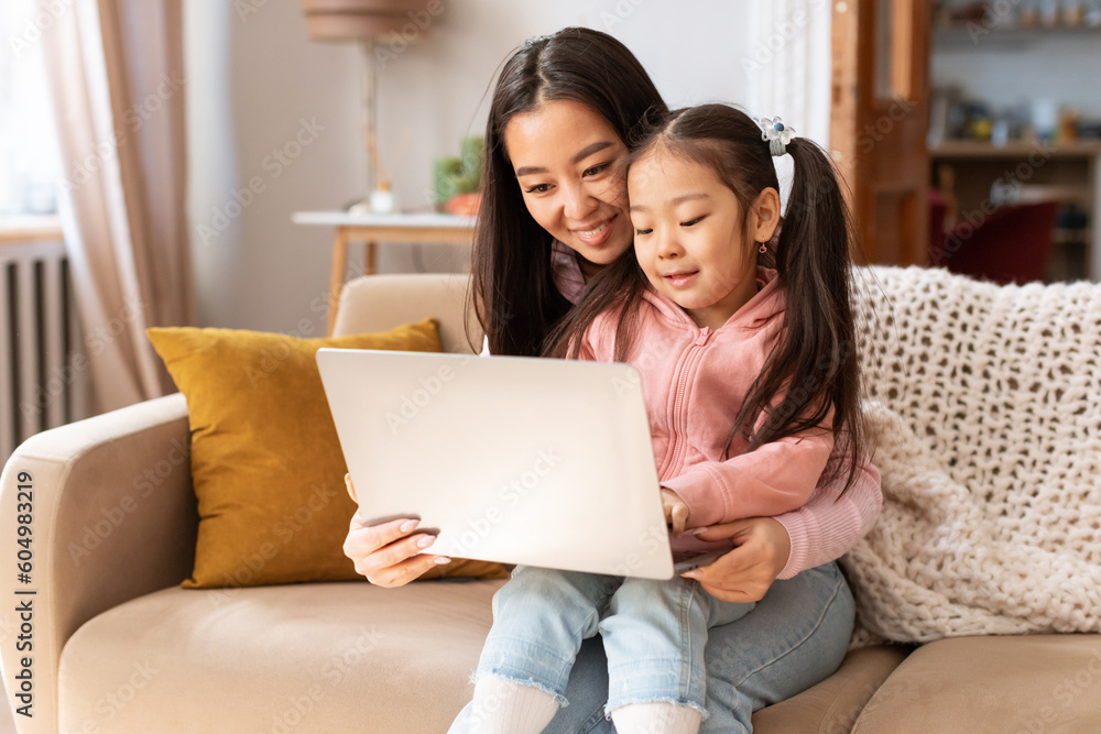 Happy Asian Mommy And Little Daughter Using Laptop At Home Happy Asian Mommy And Little Daughter Using Laptop At Home