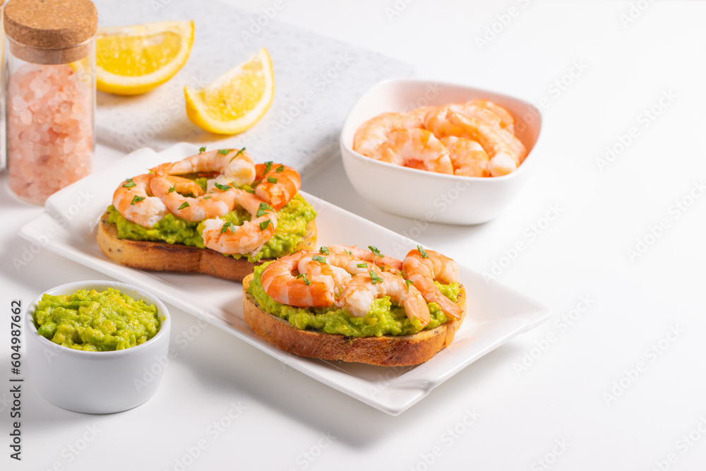 Appetizer toasted bruschetta with mashed avocado and shrimps on background. Healthy food concept with prawns. Appetizer toasted bruschetta with mashed avocado and shrimps on background. Healthy food concept with prawns.